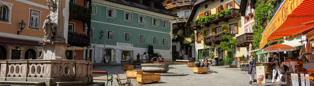 Historischer österreichischer Ortsplatz mit Brunnen und Gebäuden